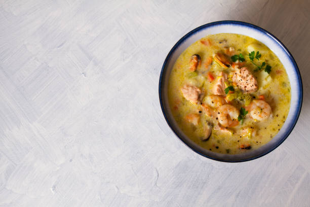 istock Bowl of seafood chowder with salmon on white background 1207517576