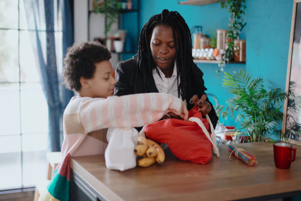 istock Mother and daughter unpacking groceries at kitchen 1207517971