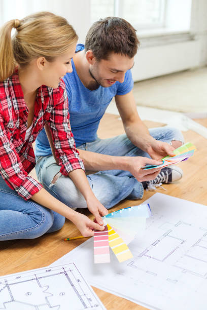 istock smiling couple with blueprints looking at color samples at home 1207522228