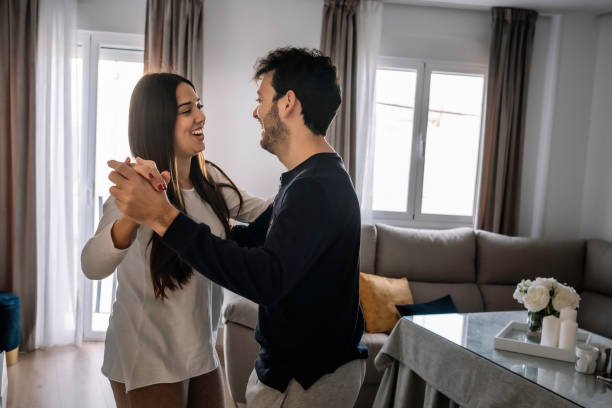 istock young couple smiling, dancing inside their house 1207522337