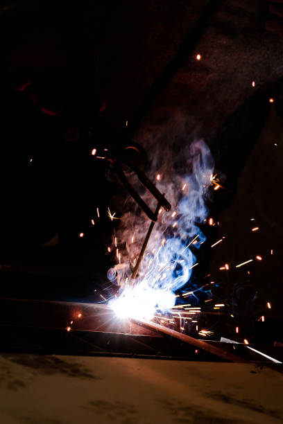istock worker in protective uniform and mask welding metal. 1207525480