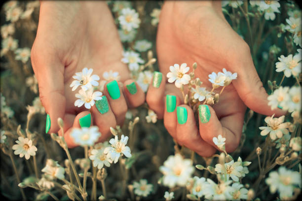 Hands with short matte manicured nails and white flowers
