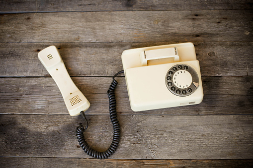 Old telephone on wood background.