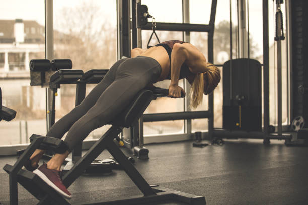 istock Woman lifting a weight to work out her lower back muscles 1207528274