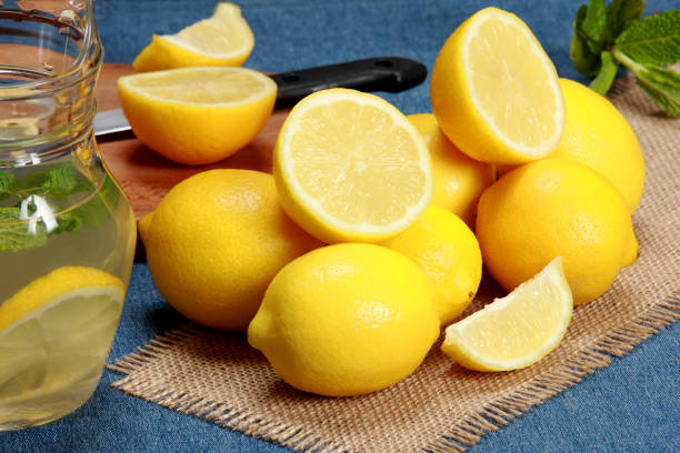 istock Freshly Picked Lemons Whole and Halved on Blue Background 1207528293