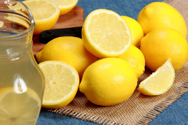 istock Freshly Picked Lemons Whole and Halved on Blue Background 1207528299