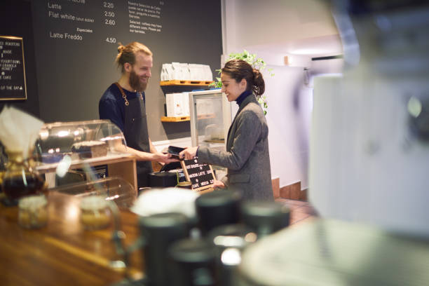 istock Costumer paying contactless with a smartphone in a coffee shop. 1207528536