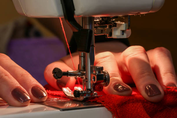 istock Sewing on sewing machine with beautiful female hands 1207530384