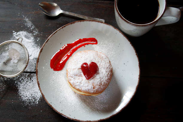 istock Jelly filled donut with powdered sugar on a ceramic plate. Top view 1207530825