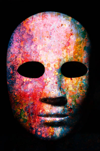 istock Textured mask with cracked rough wood  painted surface, neutral expression on dark background. 1207532152