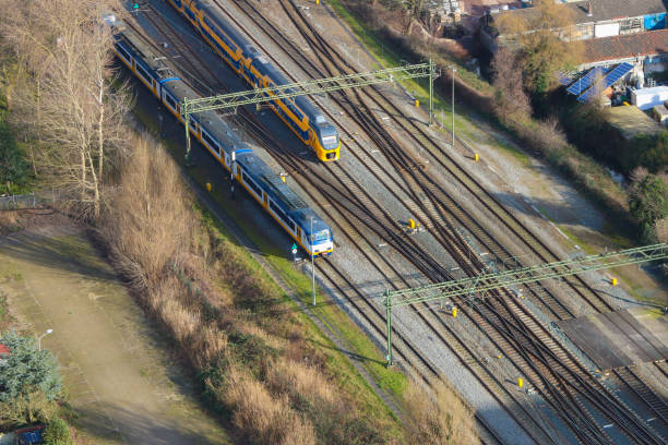 Dutch trains travelling on rail tracks shot from high angle The Hague, the netherlands - February 2 2020: Dutch trains travelling on rail tracks shot from high angle drone style shot tasrail stock pictures, royalty-free photos & images