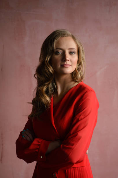 istock Red dress babe laughing against red wall 1207535821