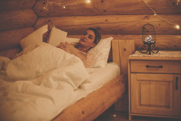 nachtgewohnheiten auf dem bett - rustic bedroom cabin indoors stock-fotos und bilder