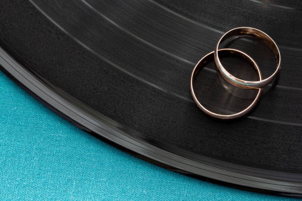 Two gold wedding rings lie on vinyl disc