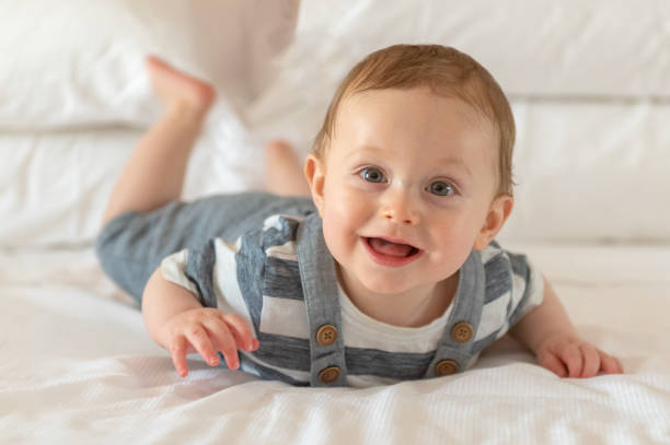 istock Boy boy 8 months old lying and smiling on bed 1207538990