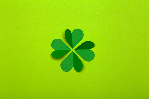 St. Patrick 's Day (St. Paddyâs Day) background concept. Green clover from paper on a green background. Clover is a symbol of Ireland and Celtic culture.