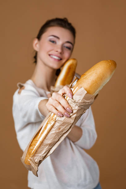 istock young woman holding bread 1207539543