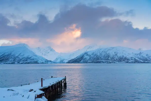icy winterlandscape with dramatic sky on Kvaloeya Island near Tromsoe in northern Norway, landscape photography