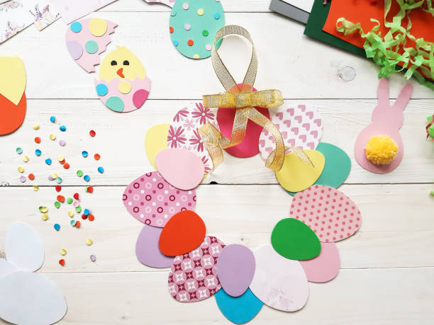 istock The child makes crafts with his own hands for the Easter. Colorful handmade from multi-colored paper. Scissors, cardboard, eggs, chicken, rabbit. Art creativity on a wooden table. Top view, copy space 1207541465