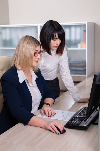 istock Two young beautiful weman work in the office. Copmuter teamwork. 1207542289