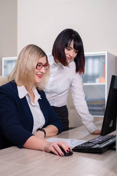 istock Two young beautiful weman work in the office. Copmuter teamwork. 1207542319