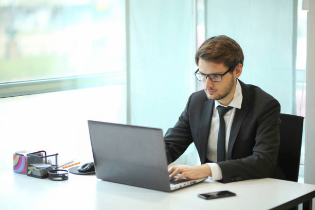 istock Portrait of confident young business man using laptop 1207542990