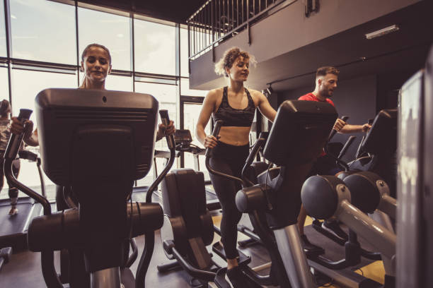 istock Athletic group of people using elliptical machine at the gym 1207548100