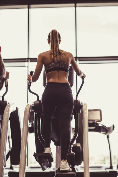 istock Fit female using elliptical at the gym 1207548714