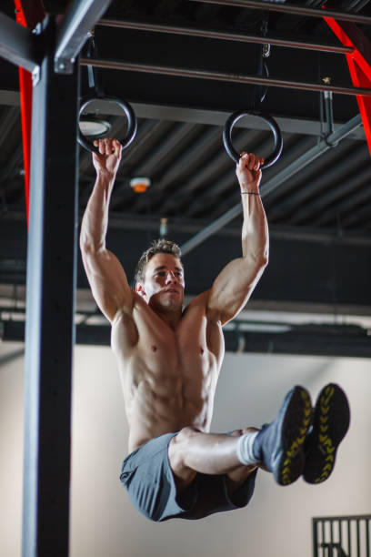 istock Muscular male athlete working on his strength by using gymnastic rings 1207548951