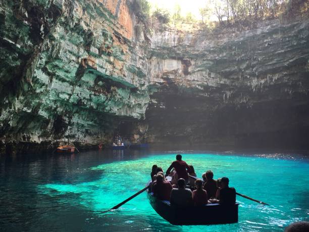 Kefalonia, Greece - Jun 06, 2018: Tourists visiting Melissani lake and cave and taking tour with boats. Melissani lake is located near Sami, small town and port on Kefalonia island. Many tourists visiting this place all over the year.