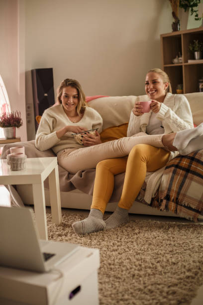 istock Cheerful girlfriends having a laugh while watching a movie together 1207549290