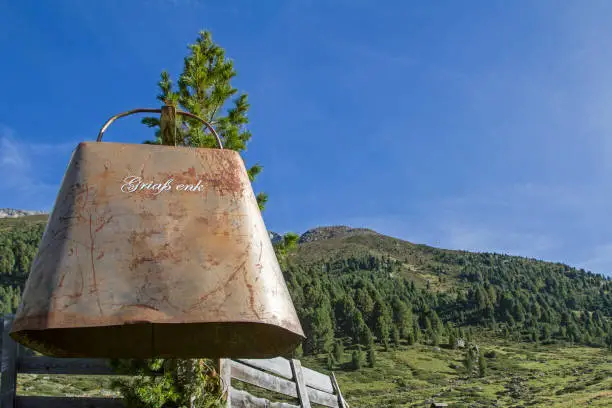 An oversized cowbell welcomes mountain hikers in the Horlach valley and invites them to a stop in the rustic alpine hut
