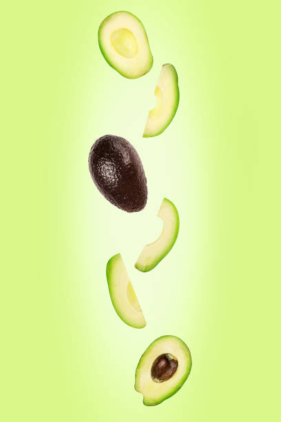 istock Falling avocado isolated on green background with clipping path as package design element and advertising. Flying foods. 1207559880