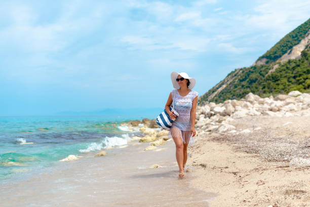 istock A women in white is walking by the water 1207564221