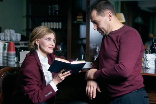 istock Happy business people working together in a restaurant writing in notepad 1207571710