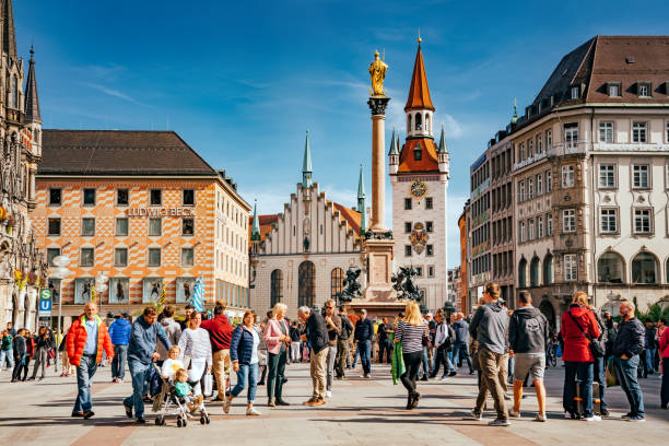 Munich, Germany - September 20, 2019: Marienplatz  and Old Town Hall (Altes Rathaus) of Munich in sunny day. Marienplatz is the most important town square of Munich and is a pedestrian zone. Tourists and locals stroll in the square in front of the ancient monument.