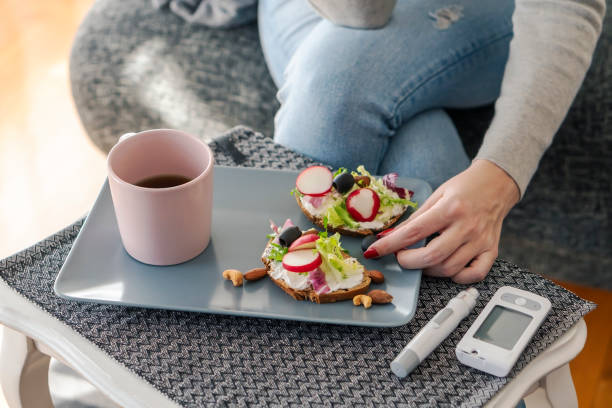 Young diabetic woman having breakfast at home stock photo