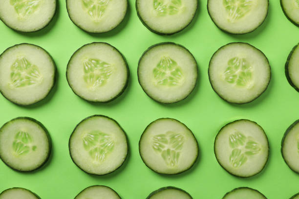 istock Fresh cucumber slices on green background, top view 1207573195