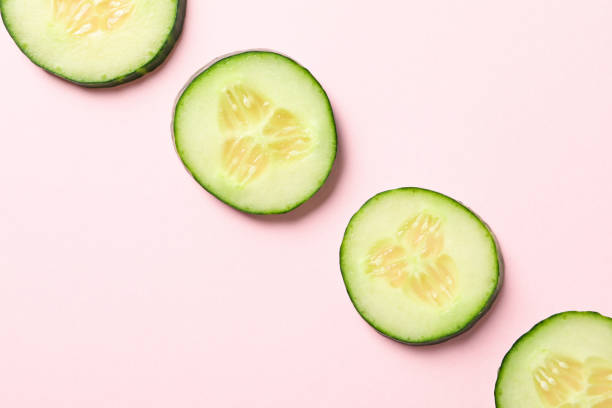 istock Fresh cucumber slices on pink background, top view 1207573386