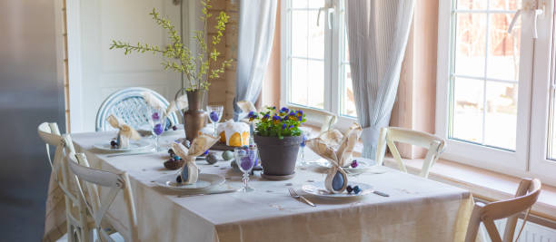 istock Easter festive spring table setting decoration, bunny ears shaped napkins, dyed eggs, cakes, flowers, selective focus 1207573391