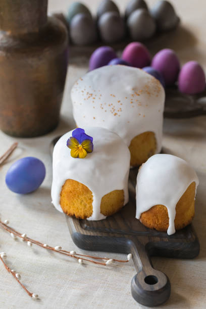 istock Easter cakes with violet flower and dyed eggs on linen background 1207573395
