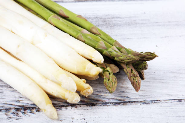 istock White and green asparagus on rustic background. 1207576684