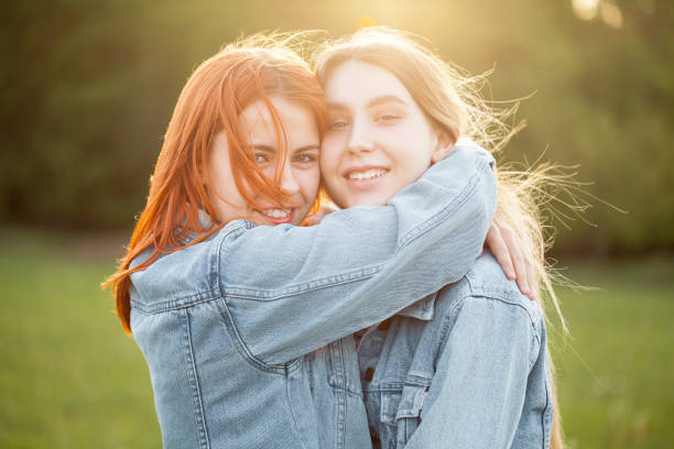 istock Two girls hugging outdoors 1207576703