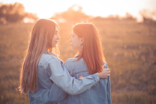istock Two young women standing on the field at sunset 1207576717