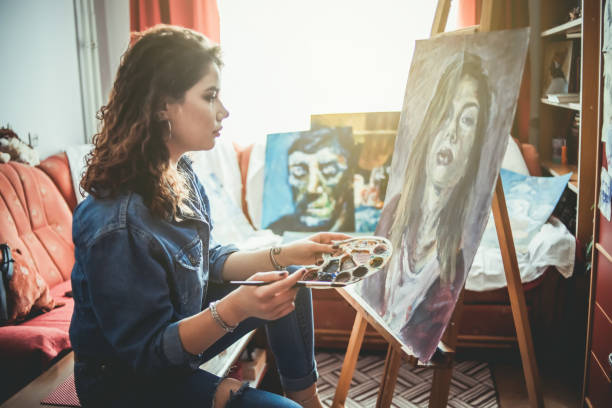 istock Creative young artist painting at home 1207576885