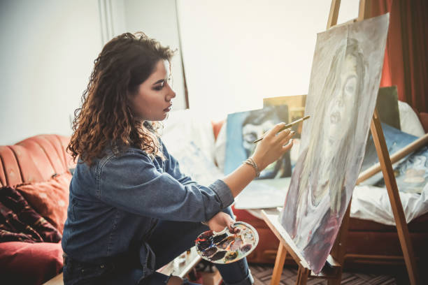 istock Creative young artist painting at home 1207576900