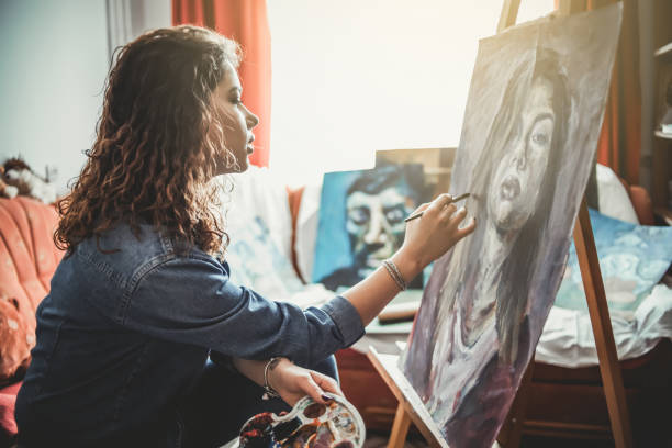 istock Creative young artist painting at home 1207576974