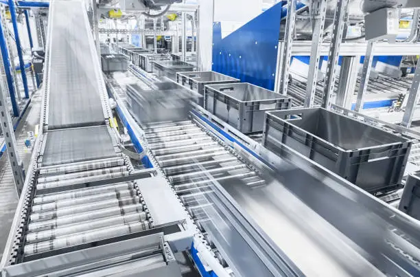 Photo of Modern conveyor system with boxes in motion.