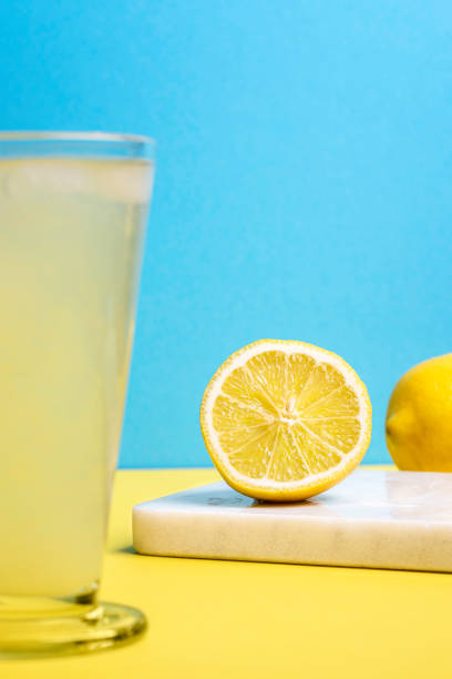istock Organic lemon cut in half and lemonade glass. Summer refreshment 1207577533