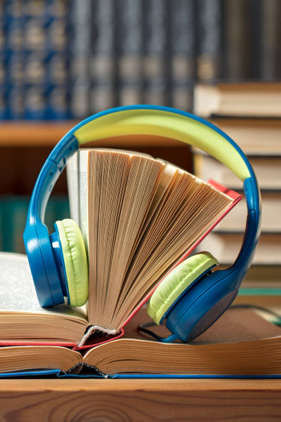 istock Audio book concept - headphones with books at the library 1207580301